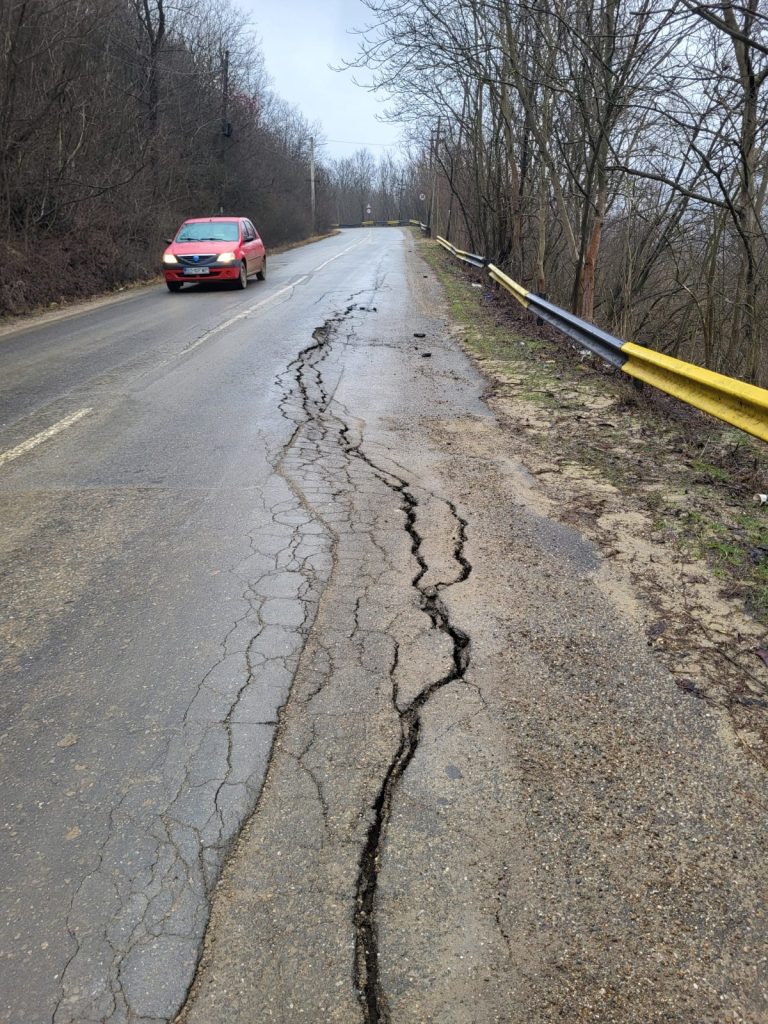 (GALERIE FOTO) Alunecare de teren pe un drum județean, aflat în licitație de doi ani, sau cum poți aștepta cu anii reabilitarea unui drum